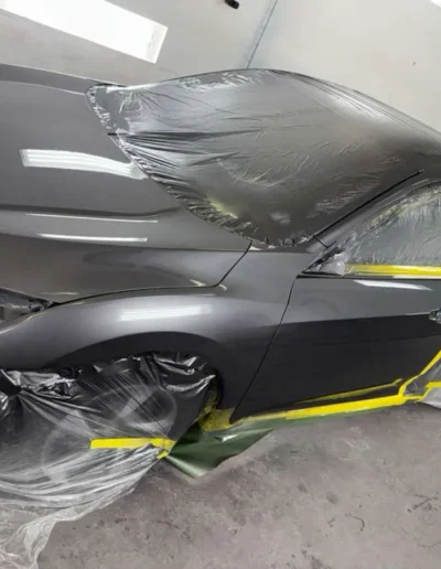 A sedan in a premium satin finish, fully masked in the booth