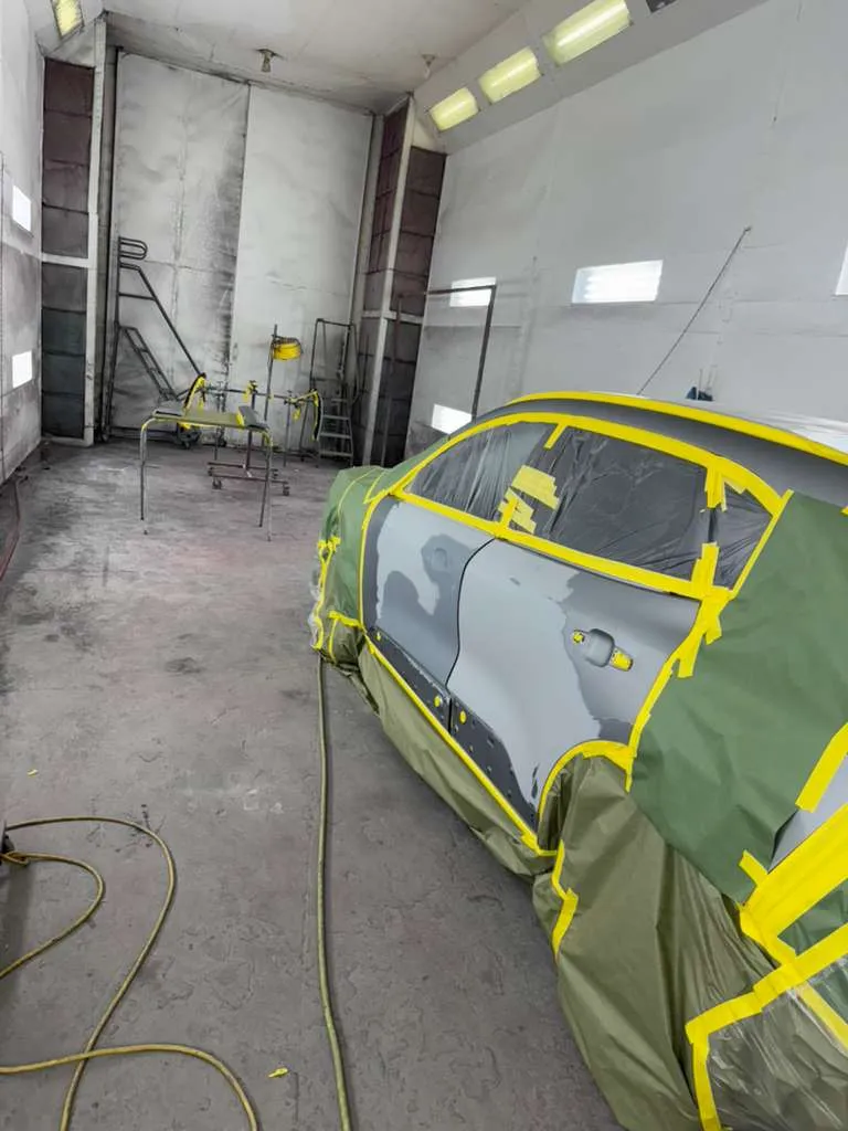 SUV with grey body filler patches on the door and quarter panel